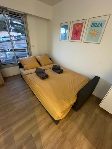 - une chambre dotée d'un grand lit avec des draps jaunes dans l'établissement Studio cosy au cœur de Cannes, à Cannes