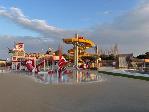 - un parc aquatique avec une aire de jeux dotée d'un toboggan dans l'établissement Mobil-home les pieds dans l'eau camping les dunes, à Torreilles