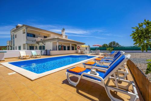 a swimming pool with lounge chairs and a house at Villa Casa Grande by Villa Plus in Albufeira