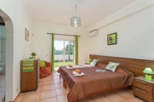 a bedroom with a large bed and a window at Villa Casa Grande by Villa Plus in Albufeira