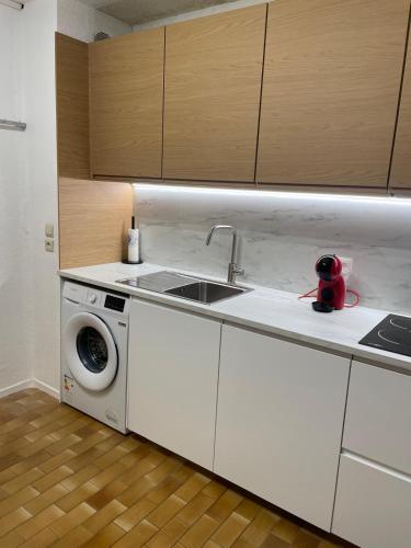 a kitchen with a sink and a washing machine at Le Marc-en-ciel in Leucate-Plage