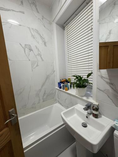 un bagno bianco con lavandino e vasca di Cosy Double Bedroom in Little Venice, Maide Vale a Moffat