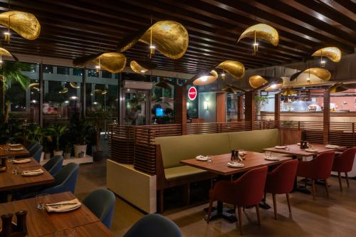 a restaurant with wooden tables and chairs and lights at Park Inn by Radisson, Riyadh in Riyadh
