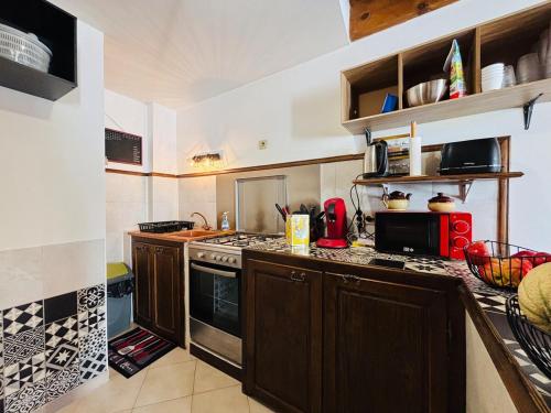 une cuisine avec des armoires en bois et un four à plaques de cuisson dans l'établissement Belle maison de montagne proche Ajaccio, à Bastelica