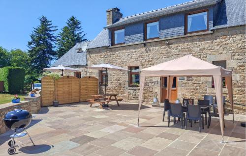 une terrasse avec des chaises et des parasols en face d'une maison dans l'établissement Ravissante Maison Bretonne, à Louargat