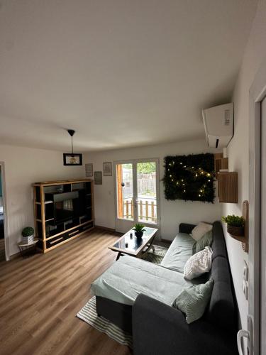 un salon avec un canapé et une télévision dans l'établissement Maison chaleureuse bassin Arcachon, à La Celle-sous-Gouzon
