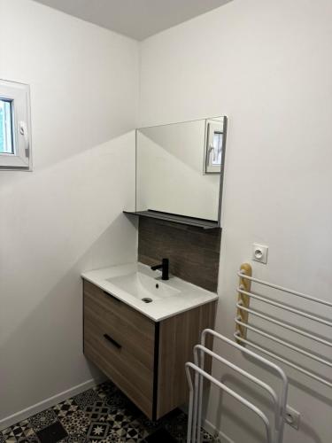 une salle de bain avec un lavabo et un miroir dans l'établissement Maison chaleureuse bassin Arcachon, à La Celle-sous-Gouzon