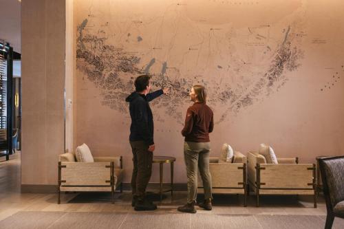 a man and woman standing in front of a painting on a wall at Hotel Cabo De Hornos in Punta Arenas