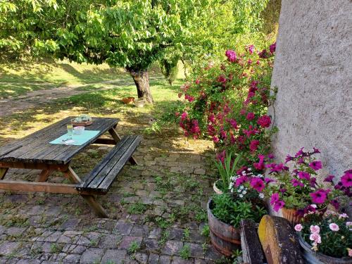 a wooden picnic table in a garden with flowers at Estudi ideal en una masia in Amer