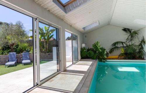 une piscine dans une maison avec des portes coulissantes en verre dans l'établissement Beautiful Home In Saint Jean De Monts, à Saint-Jean-de-Monts