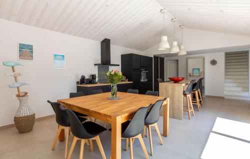 une cuisine et une salle à manger avec une table et des chaises en bois dans l'établissement Beautiful Home In Saint Jean De Monts, à Saint-Jean-de-Monts