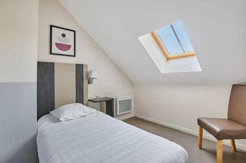 a bedroom with a bed and a window and a chair at Appart'hôtel Odalys City - Dijon Centre Les Cordeliers in Dijon