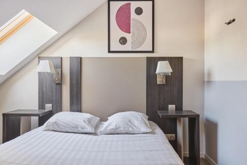 a bedroom with a bed with two side tables at Appart'hôtel Odalys City - Dijon Centre Les Cordeliers in Dijon