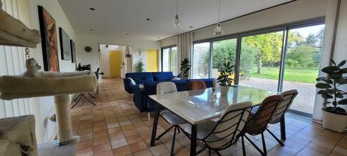 un salon avec une table et un canapé dans l'établissement Maison d'architecte avec foret et immense jardin, à Saintes