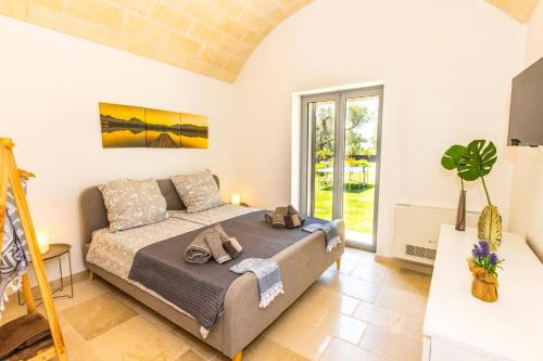 a bedroom with a bed and a large window at Villa Quattro e Cinque by Villa Plus in San Michele Salentino