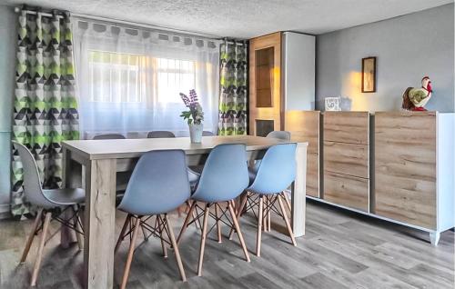 a dining room with a table and blue chairs at Amazing Home In Brodnica Górna in Brodnica Dolna