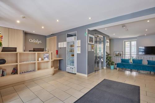 a store lobby with a blue couch and a refrigerator at Appart'hôtel Odalys City - Dijon Centre Les Cordeliers in Dijon
