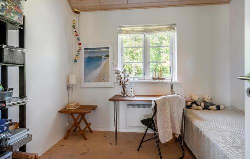 a bedroom with a bed and a desk and a window at Cozy Home In Nysted With House Sea View in Nysted