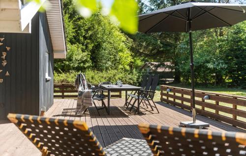 a patio with a table and chairs and an umbrella at Stunning Home In Oksbøl With Sauna in Oksbøl