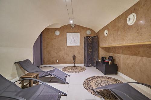 a living room with chairs and a table and a room at Appart'hôtel Odalys City - Dijon Centre Les Cordeliers in Dijon