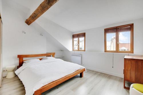 une chambre blanche avec un lit et deux fenêtres dans l'établissement Cosy Duplex City Center, à Paris