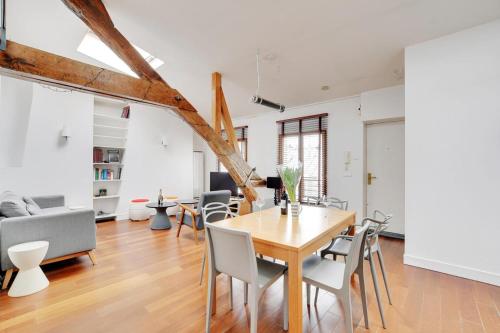 une salle à manger et un salon avec une table et des chaises dans l'établissement Cosy Duplex City Center, à Paris