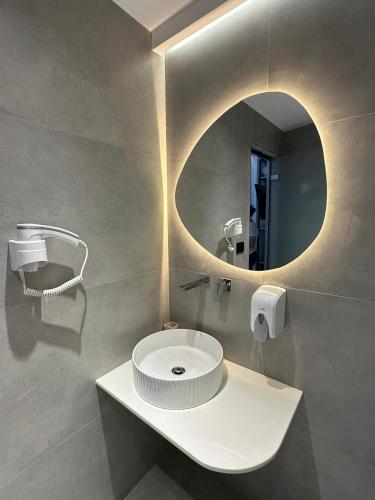 a bathroom with a white sink and a mirror at Hotel Mesun Himare in Himare