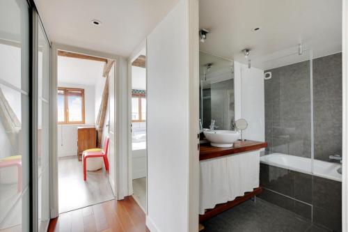 une salle de bain avec une baignoire et un lavabo et une baignoire dans l'établissement Cosy Duplex City Center, à Paris