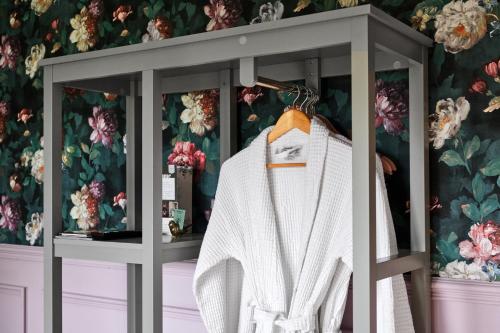 a display cabinet with a white sweater in a room with flowers at Carnbore House BnB in Bushmills