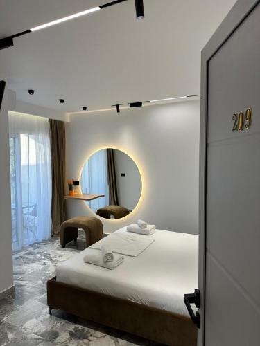 a bedroom with a bed and a round mirror at Hotel Mesun Himare in Himare
