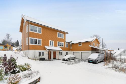 a house with two cars parked in the snow at Apartment in Tromsø in Tromsø
