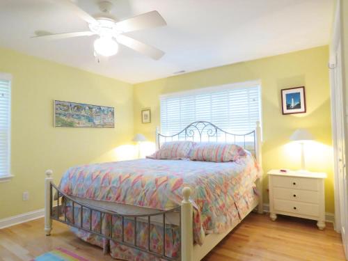 une chambre avec un lit et un ventilateur de plafond dans l'établissement Cedar Cottage, à Cape May Point