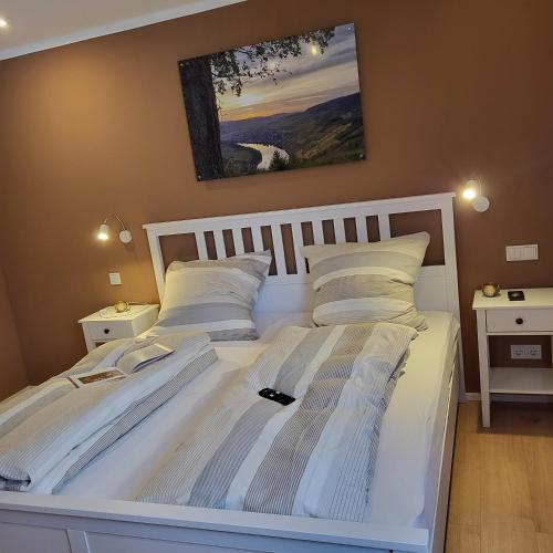 a bedroom with a white bed with two white pillows at Haus Valentonio in Zeltingen-Rachtig
