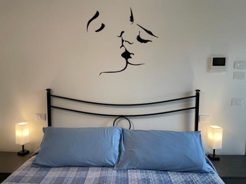 a bedroom with a bed with a black headboard and two lamps at Casa Tina in Ravenna