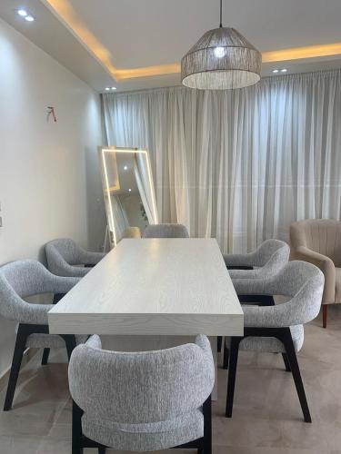 a conference room with a white table and chairs at H Flat With Roof- One Kattamya in Cairo