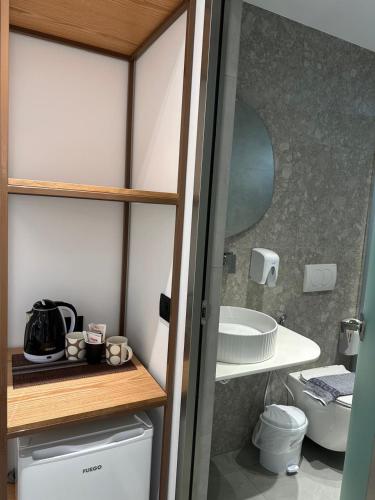 a small bathroom with a toilet and a sink at Hotel Mesun Himare in Himare