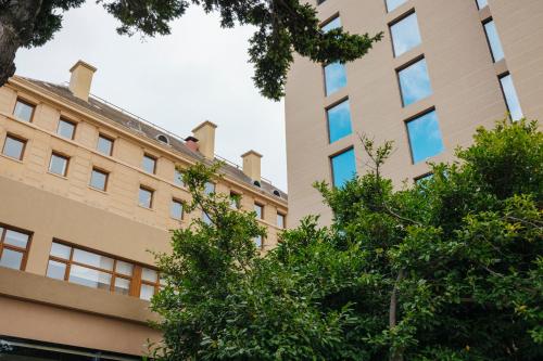 a tall building with trees in front of it at Hotel Cabo De Hornos in Punta Arenas