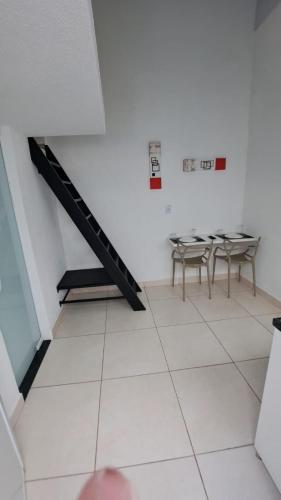 a room with tables and chairs and a staircase at Pousada do sol in Sorocaba
