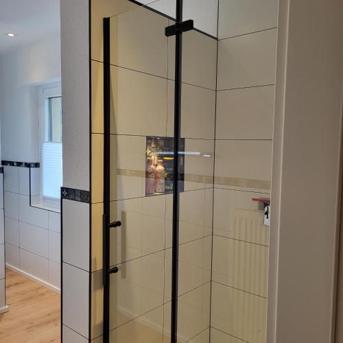 a glass shower door in a bathroom with at Haus Valentonio in Zeltingen-Rachtig
