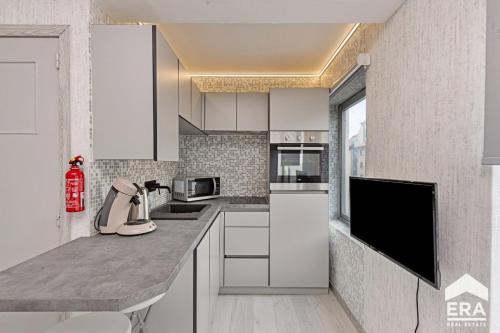 a kitchen with white cabinets and a counter top at Studio Cosy & Zen à Coxyde Dog-friendly in Koksijde