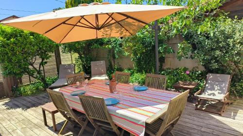 アンデルノ・レ・バンにあるVilla Les Goëlands 6 personnes à 50 m de la plageのパティオ(傘付)