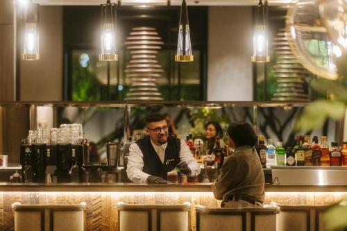 a bartender behind the bar at a restaurant at Hotel Cabo De Hornos in Punta Arenas