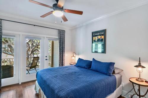 una camera con letto blu e ventilatore a soffitto di Garden Cottage 71 a Jekyll Island