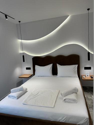 a white bed with two towels on top of it at Hotel Mesun Himare in Himare