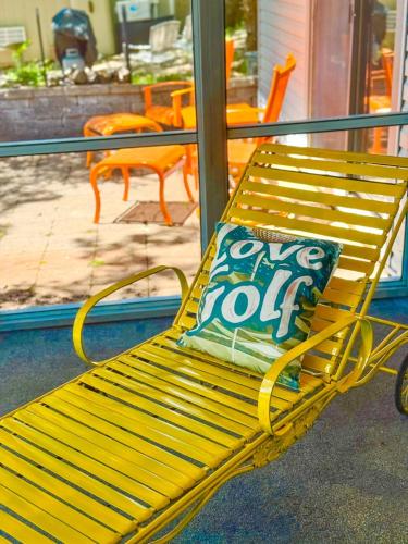 a yellow bench with a one top job pillow on it at Putters Paradise-2bed2bathgrillfirepit-10pp in Osage Beach