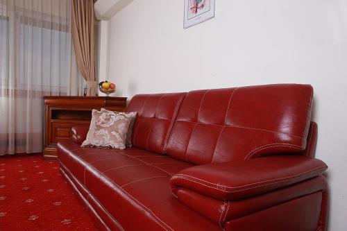 a red leather couch sitting in a living room at Hotel Moldova in Iaşi