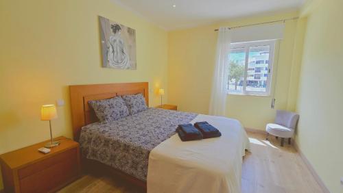 een slaapkamer met een bed en een raam bij Praia Eulália with pool and 5 minutes from the beach in Albufeira