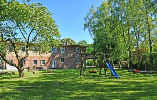 a playground with a slide in the grass in front of a building at Ferienwohnungen auf Rügen und nahe Stralsund in Poppelvitz