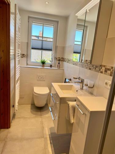 a bathroom with a toilet and a sink at Die 5 Ferienwohnungen der Familie Weber in Fehmarn