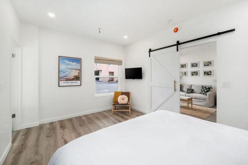 a white bedroom with a bed and a living room at Pismo Beach Club in Pismo Beach